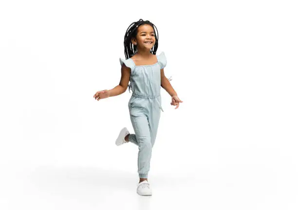 Photo of Happy longhair brunette little girl isolated on white studio background. Looks happy, cheerful, sincere. Copyspace. Childhood, education, emotions concept