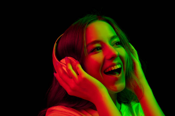 istock Caucasian woman's portrait isolated on black studio background in multicolored neon light 1302961007