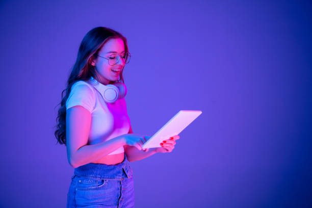istock Caucasian woman's portrait isolated on blue studio background in multicolored neon light 1302961042