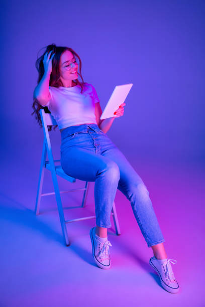 istock Caucasian woman's portrait isolated on blue studio background in multicolored neon light 1302961046