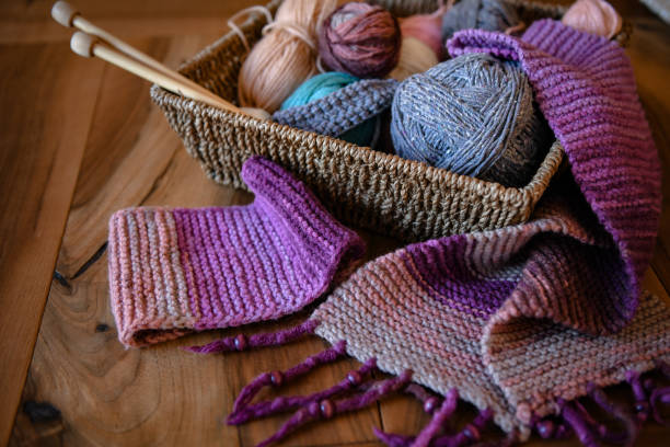 accessoires pour tricoter dans le panier (fil, aiguilles) et écharpe - tricoté photos et images de collection