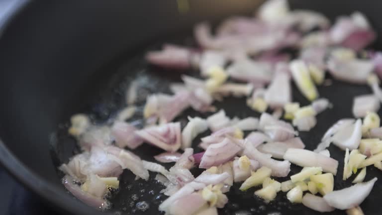 Slow Motion Onions Cooking in Pan Up Close