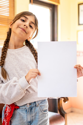 Happy cute child girl holding empty blank