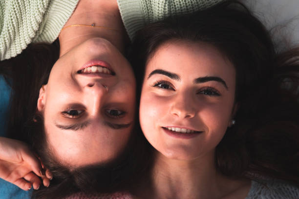 istock Two cute young women laying on a bed 1302968470