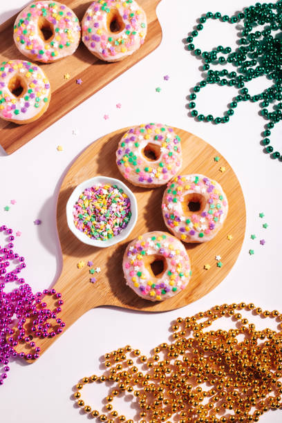 istock Mardi gras carnival sprinkled doughnuts and beads, holiday celebration, baking, top view 1302968781