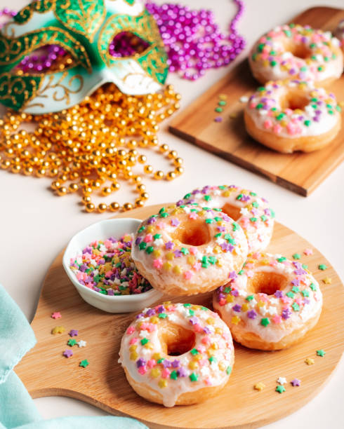 istock Mardi gras carnival sprinkled doughnuts and beads, holiday celebration, baking, top view 1302968792