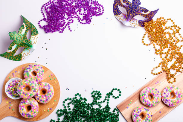Mardi gras carnival sprinkled doughnuts and beads, holiday celebration, baking, top view