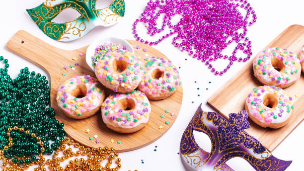 istock Mardi gras carnival sprinkled doughnuts and beads, holiday celebration, baking, top view 1302968826