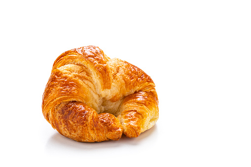 Close up view of fresh homemade croissant isolated on white background. Predominant colors are yellow and white. High resolution 42Mp studio digital capture taken with Sony A7rII and Sony FE 90mm f2.8 macro G OSS lens
