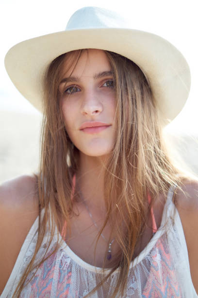 istock Young woman wearing sun hat looking at camera pensively 1302972077
