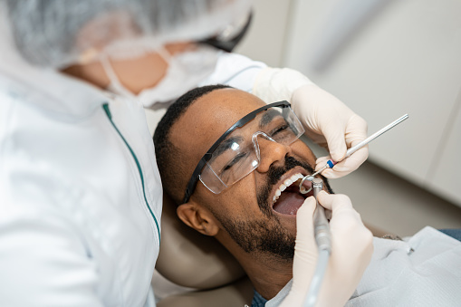 Dentista usando taladro dental photo
