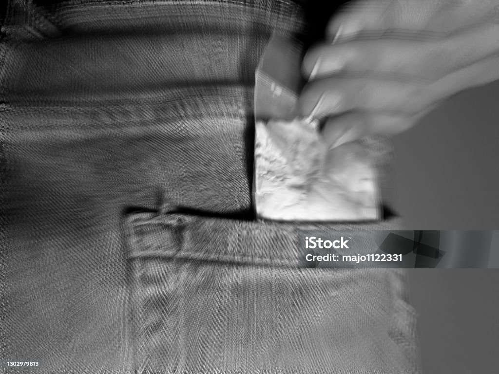 Man puts cocaine powder bag into back jeans pocket Man puts cocaine drug powder bag into back jeans pocket Abuse Stock Photo