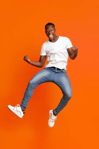 istock Black guy winner jumping up and showing funny figures 1302982467