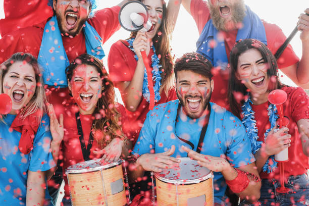 istock Crazy football supporters playing drums and screaming while supporting their team - Focus on bottom man 1302982699