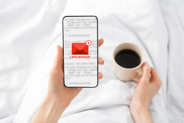 istock Woman Holding Phone With E-Mail Message Lying In Bed Indoor 1302984881