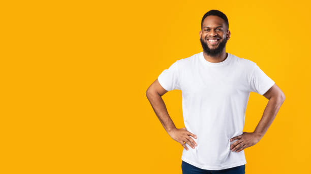 istock Happy African Man Standing Posing Near Empty Space, Yellow Background 1302985851