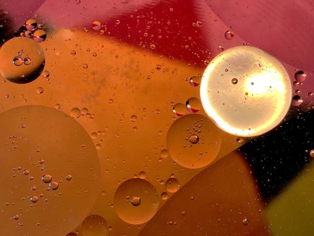 istock Illuminated drops of oil floating in the water 1302986310