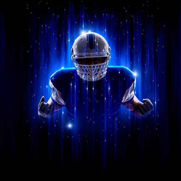 held fußballer trägt eine blaue uniform - football helmet american football yellow american football uniform stock-fotos und bilder