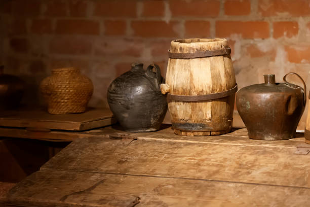 istock Retro jugs and a barrel in an old brick basement. 1302992611