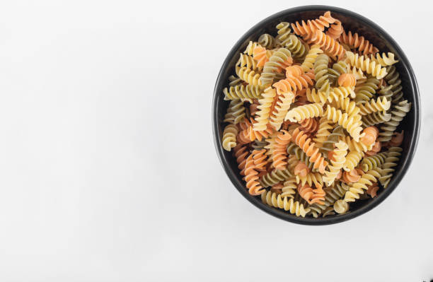 istock Raw colorful fusilli pasta in dark bowl 1302992633