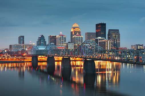 Louisville, Kentucky, USA downtown skyline on the Ohio River at dusk.