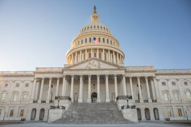 здание капитолия в вашингтоне, округ .c с ярко-голубым небом. - washington dc capitol building american flag sky стоковые фото и изображения