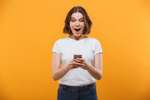 istock Excited young woman chatting by mobile phone 1303000992