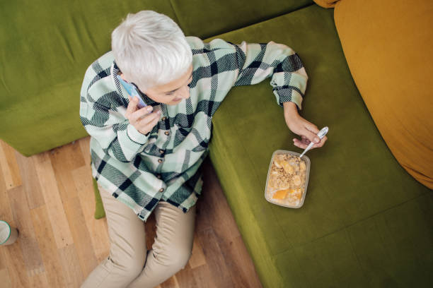 happy mature woman talking on the phone during breakfast - lunch box box old green imagens e fotografias de stock