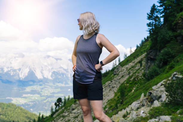 woman hiking on beautiful summer day in alps mountains Austria, resting on rock and admire amazing view to mountain peaks. Active family vacation leisure with kids. Outdoor fun and healthy activity mujer haciendo senderismo en hermoso día de verano en las montañas alpes austria, descansando en roca y admirando una vista increíble a los picos de montaña. ocio activo de vacaciones en familia con niños. diversión al aire libre y actividad saludabl