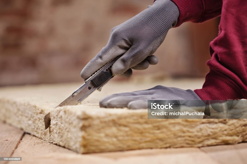 Cutting Mineral wool with utility knife Mineral Wool Stock Photo