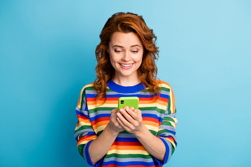 Photo of wavy hairdo person hands hold device write sms wear pullover isolated on blue color background.