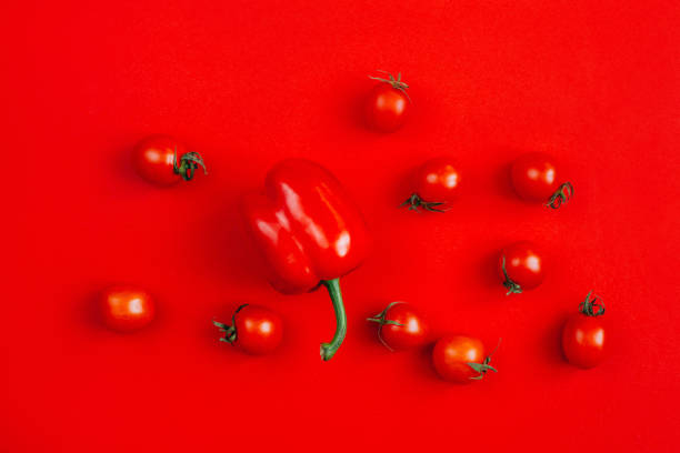istock top view of tomatoes and peppers on red background 1303006871