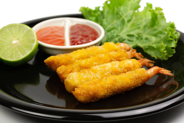 istock breaded shrimp on black plate isolated on white background 1303009620