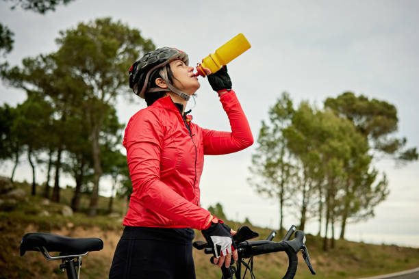 спортсменка в начале 50-х принимая перерыв во время езды на велосипеде - cycling bicycle triathlon women стоковые фото и изображения