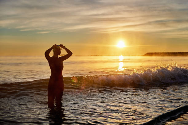istock Female Swimmer Putting on Goggles in Mediterranean at Dawn 1303009778