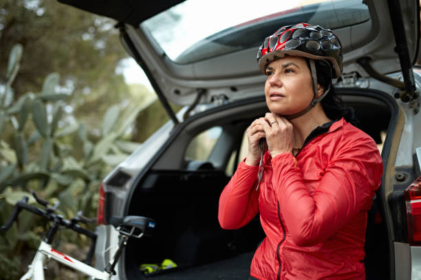 istock Hispanic Woman Putting on Cycling Helmet Before Training 1303009860