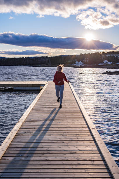 istock Sportswoman running on pier. 1303010722