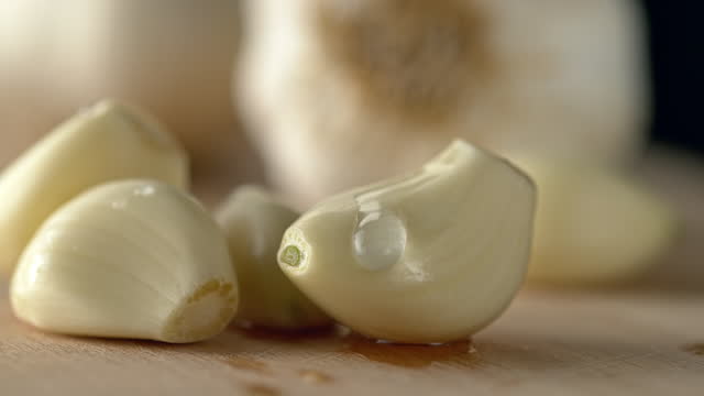 SLO MO LD Waterdrop gliding down a garlic clove