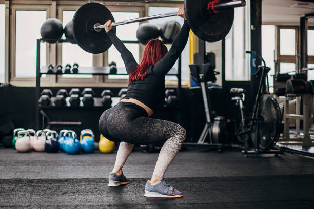 istock Woman training with weights in gym 1303012051