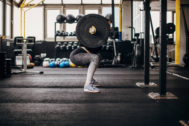 istock Woman training with weights in gym 1303012104