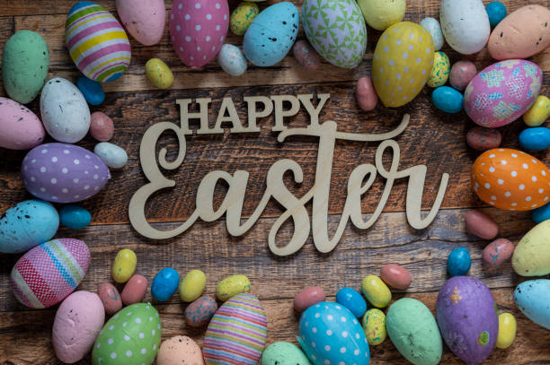 istock Happy Easter text on a wooden background with colorful Easter Eggs 1303012891