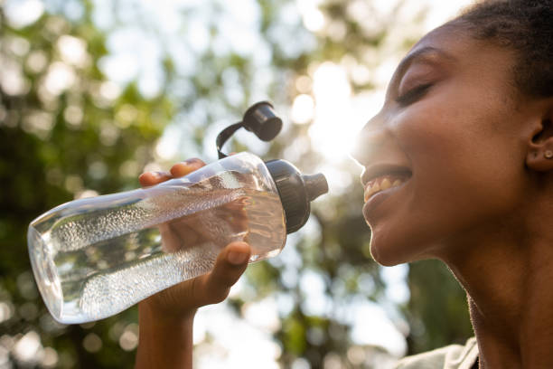 una donna con bottiglia d'acqua - reuseable foto e immagini stock