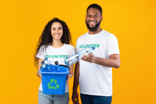 istock Two Volunteers Holding Box Full Of Plastic Bottles In Studio 1303013460