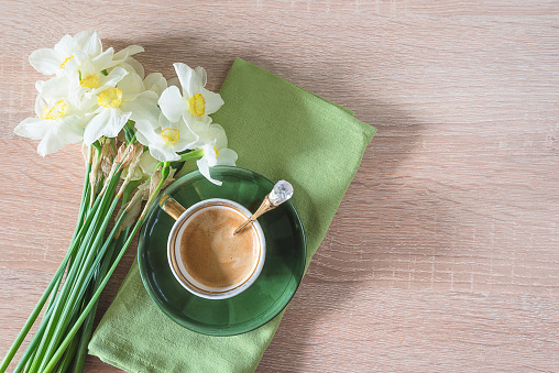 Spring coffee break with bouquet of daffodils