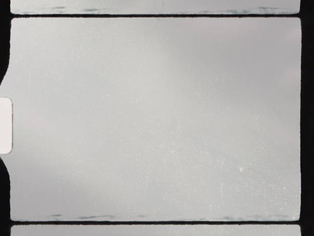 istock empty or blank 8mm film frame with black border and dust. 1303015578