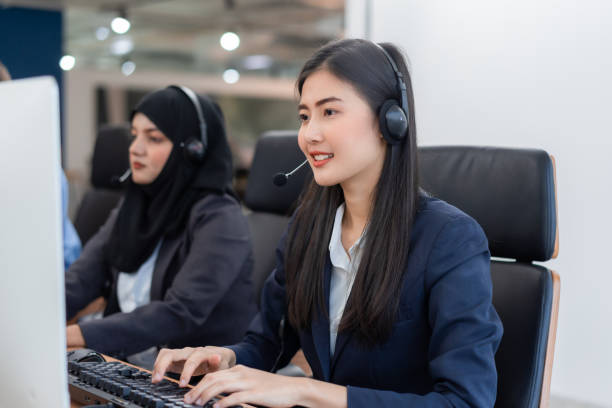 istock Happy smiling operator asian woman customer service agent with headsets working on computer in a call center, talking with customer for assisting to resolve the problem with her service mind 1303016582