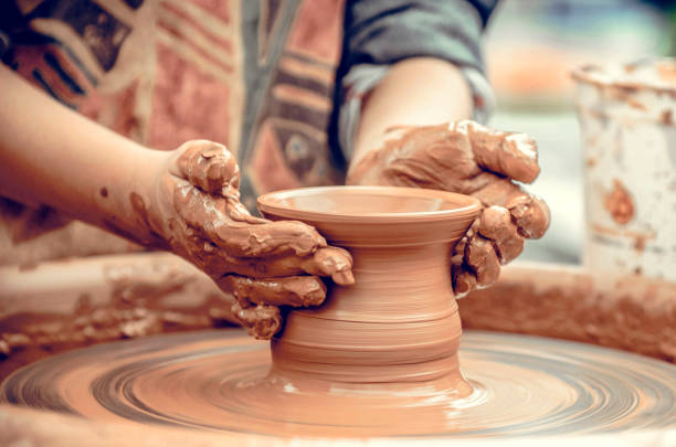 istock Hands of a potter at work. Potter making ceramic mug on the pottery wheel 1303016601