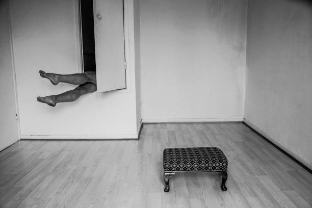istock Legs emerging from a cupboard/closet. A foot stool positioned centrally on the floor in what could be a studio of sorts. 1303018095