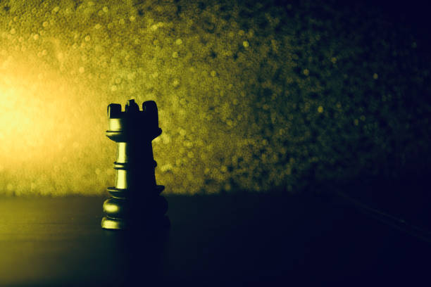Plastic chess pieces with yellowish lights background
