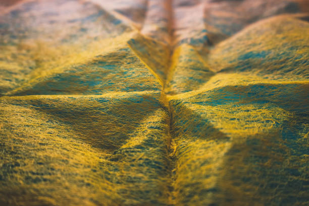 close up view of thin orange fabric over blue backdrop imitating surface topography